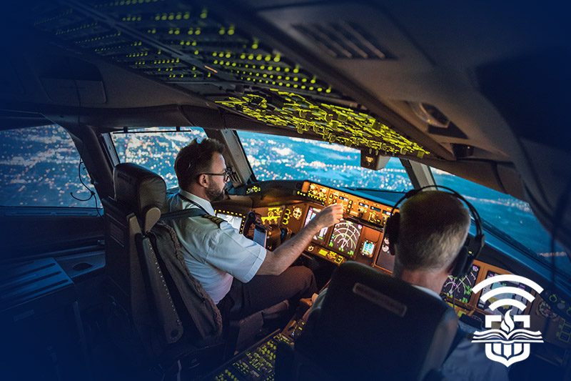 Two pilots in a cockpit with the city skyline below them