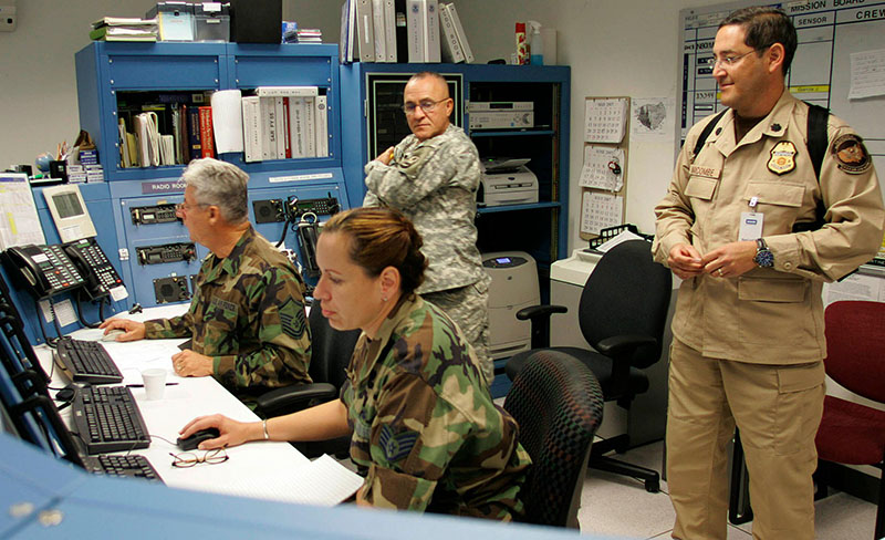 a woman sitting with two law enforcement officers