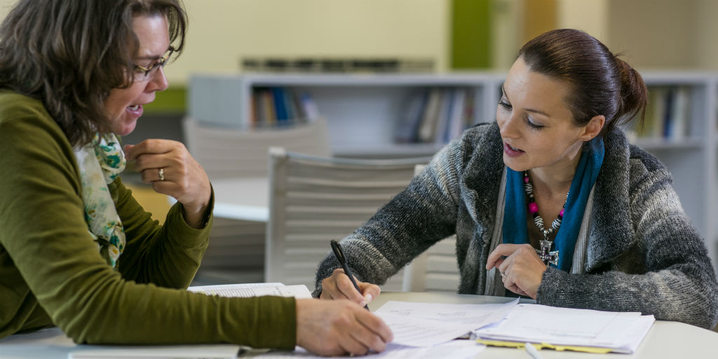 Female professor working with female student