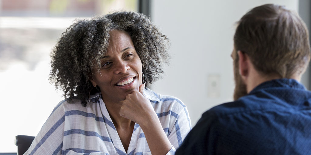 A man speaking with a man and a woman