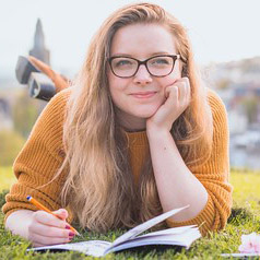 young student reading outside