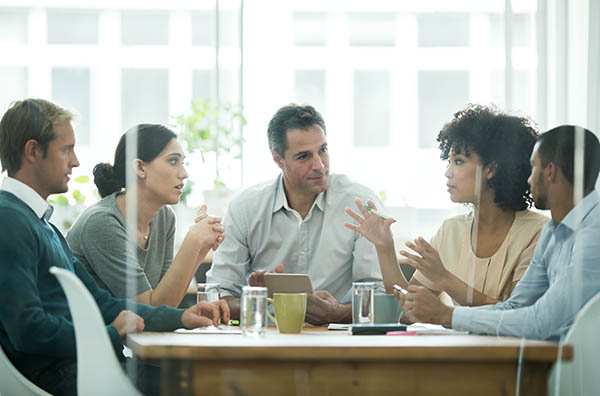 female manager presenting to workers at a boardroom table