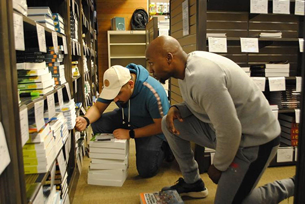 Pernell Thomas looks for a book at the Texas A&M University-Central Texas bookstore Tuesday as Thomas Torres, a bookstore employee helps him out.