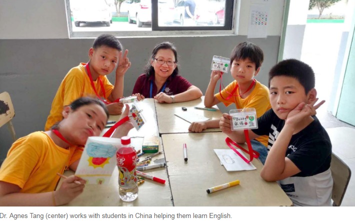 Image of Dr. Agnes Tang with Students in China helping them learn English