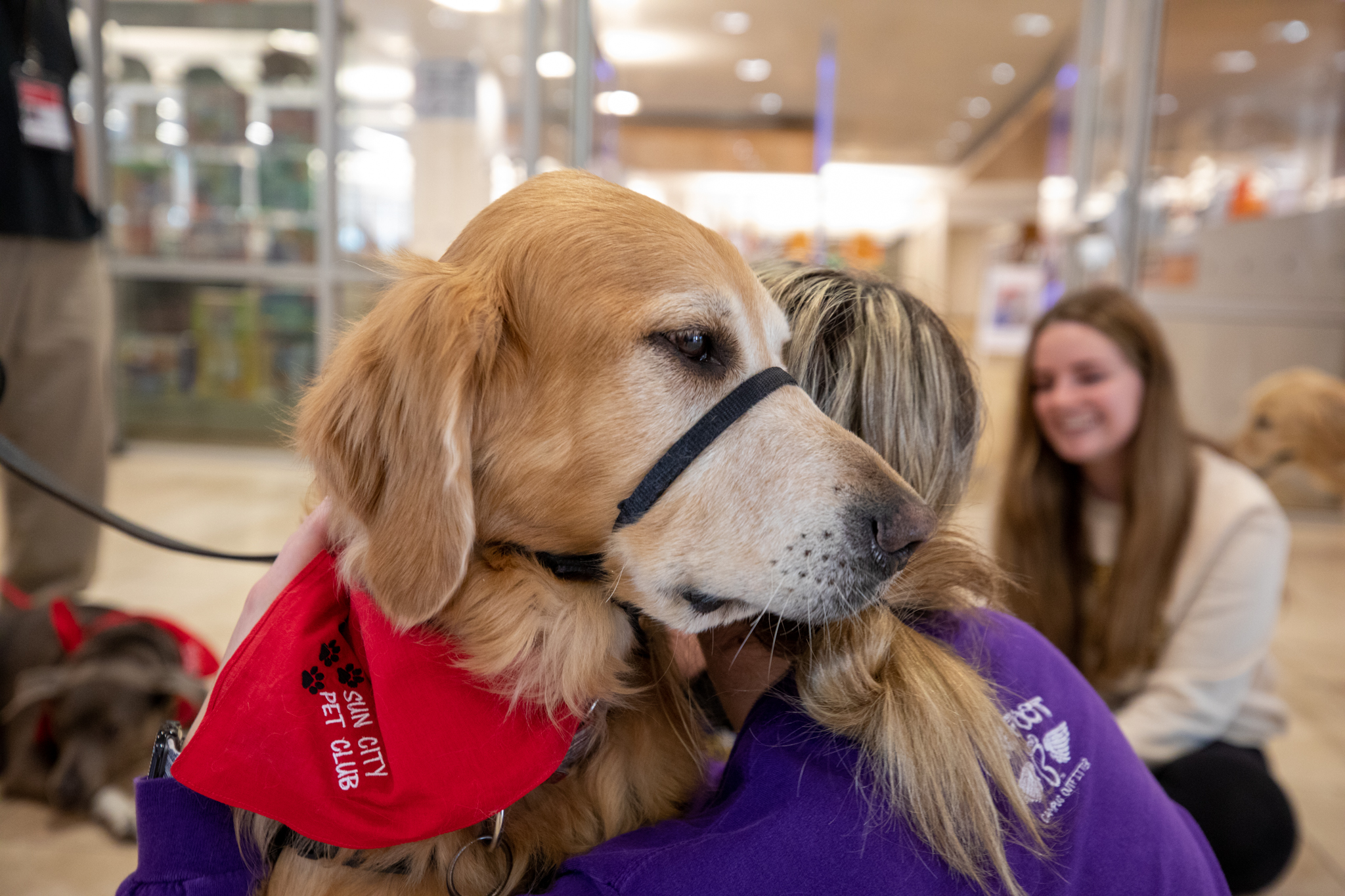A student hugs a therapy dog