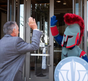 University President Richard M. Rhodes high-fiving A&M-Central Texas' mascot, Pathfinder.