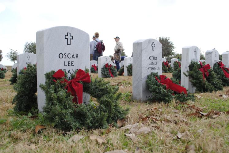 wreaths in front of headstones