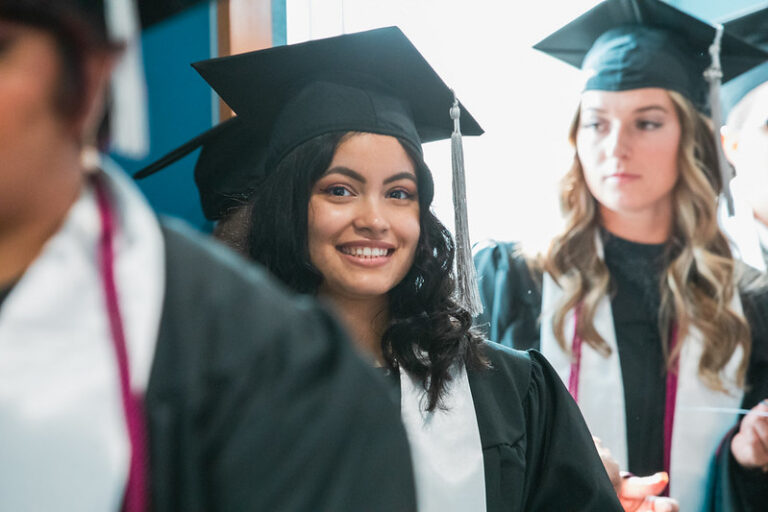 TAMUCT graduate in cap and gown.