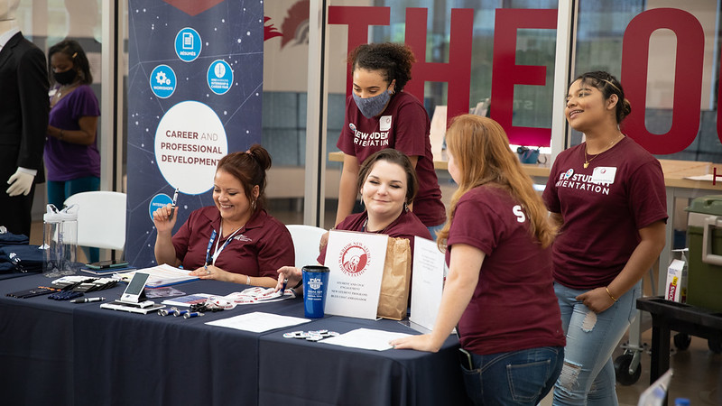 A group of five people gathered around a table for New Student Orientation.