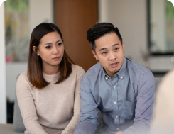 A seated couple discuss tuition assistance with a counselor.