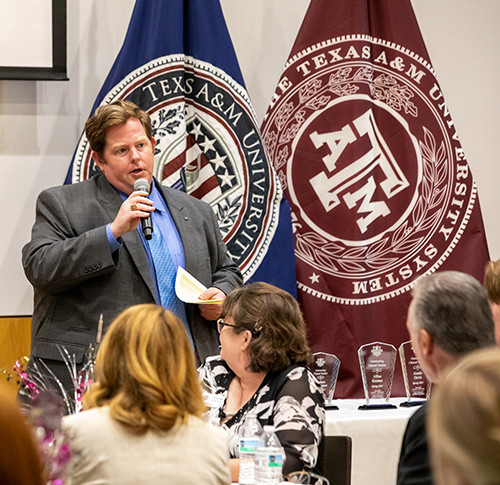 A man speaks into the microphone at Teacher Education Orientation