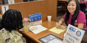 Priscilla Kim, an accounting graduate student, assisting a student in military uniform with VITA