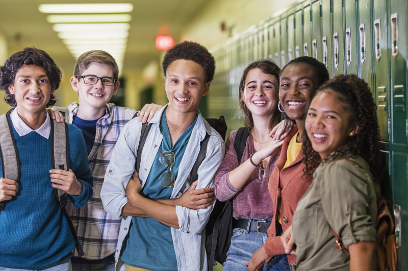 6 students standing in a school hallway taking a picture together