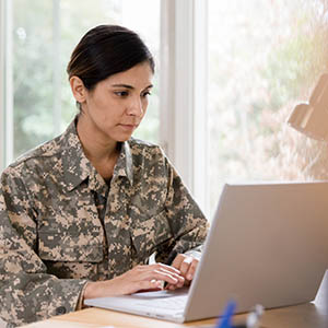 Female soldier concentrates while working from home