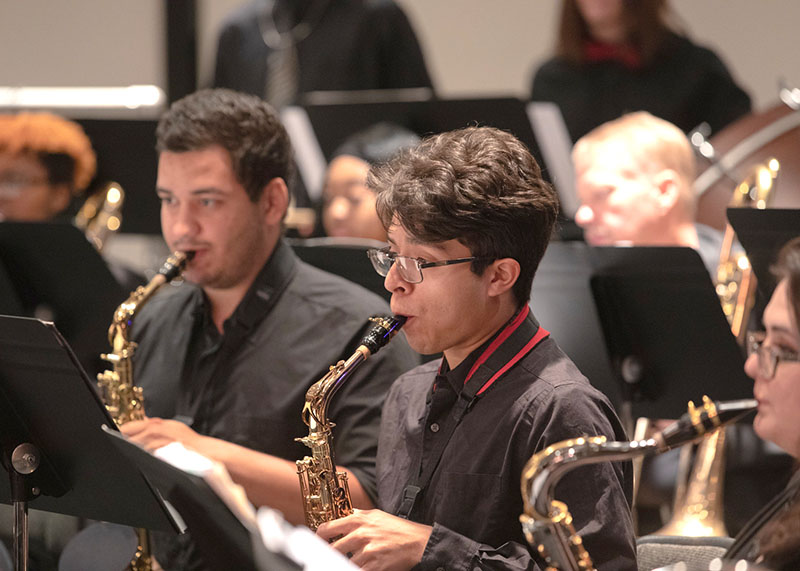 A group of saxophone players in front of their sheet music
