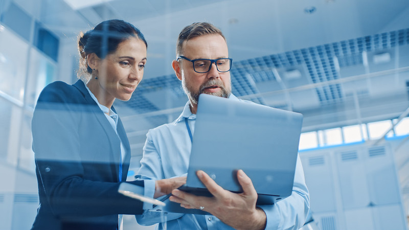 Two people working on a laptop