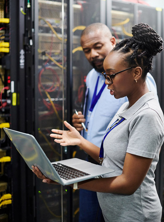 A woman and a man talk to each other in a server room