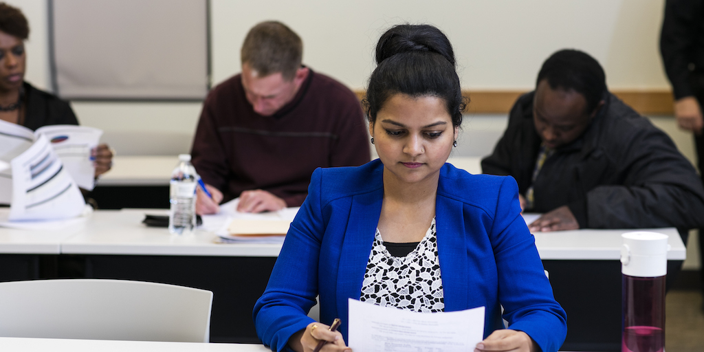 Woman at a table reading a piece of paper