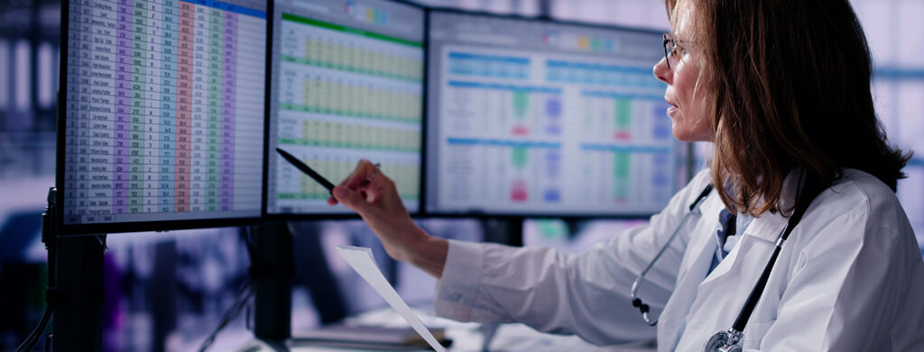 Nurse looking at computer screens reviewing data