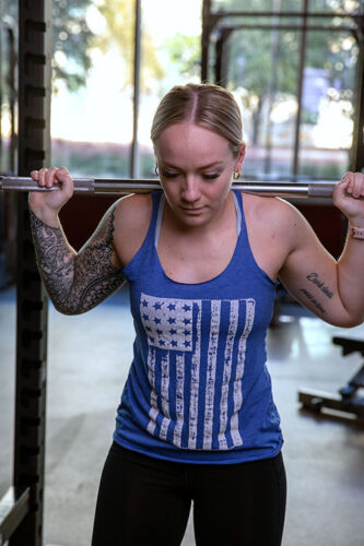 Student working out, at bars, back squat