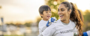 Photo of a smiling volunteer playing with a child.