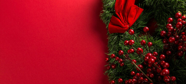 Photo of a festival holiday background with red wrapping paper and pine