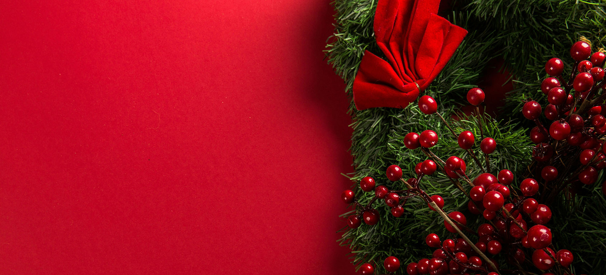 Photo of a festival holiday background with red wrapping paper and pine