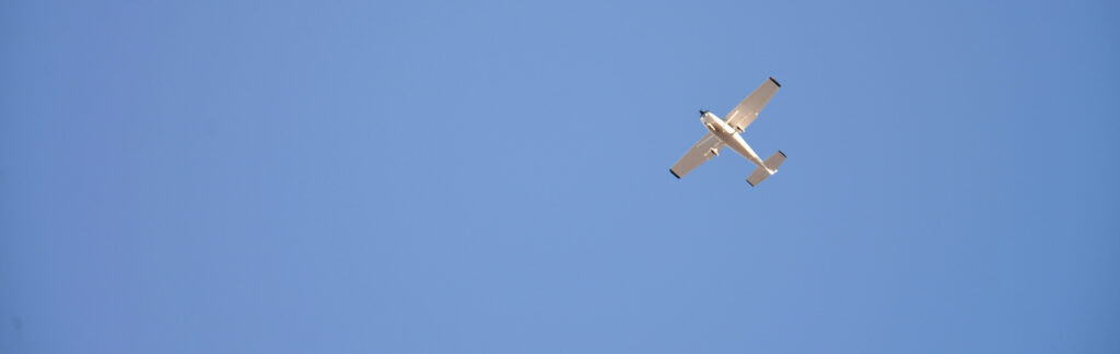 Photograph of training aircraft flying against a blue sky.
