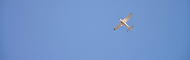 Photograph of training aircraft flying against a blue sky.