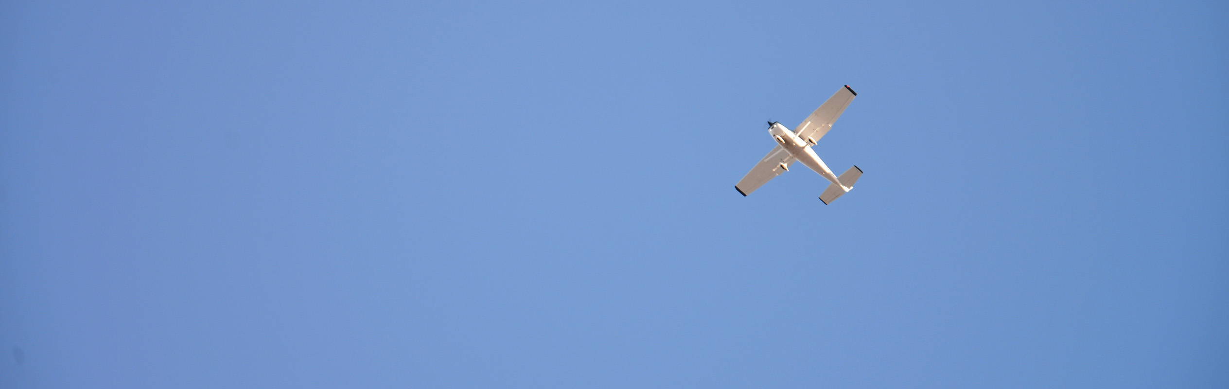 Photograph of training aircraft flying against a blue sky.