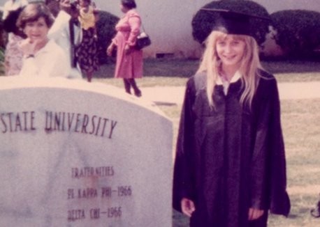 Schwegler as a child wearing her mother's graduation cap and gown.