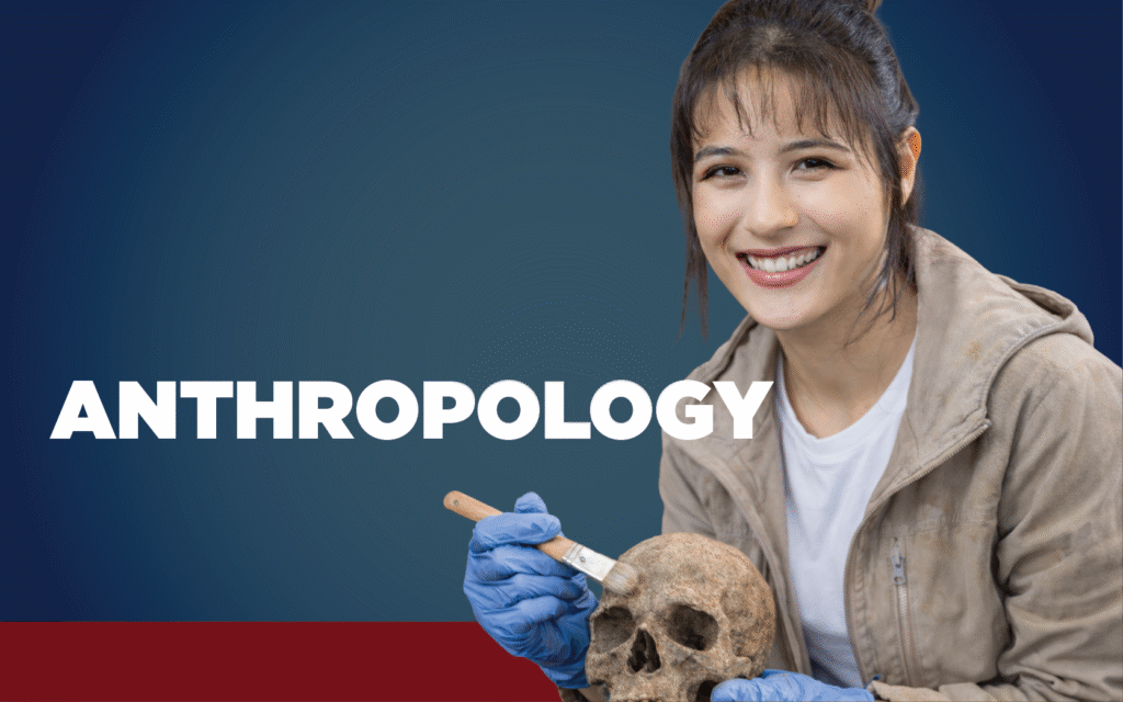 Woman wearing a jacket and gloves dusting off a skull with the word anthropology displayed.