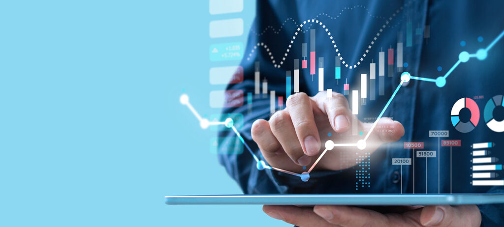 hand on computer, showing numbers and graphs