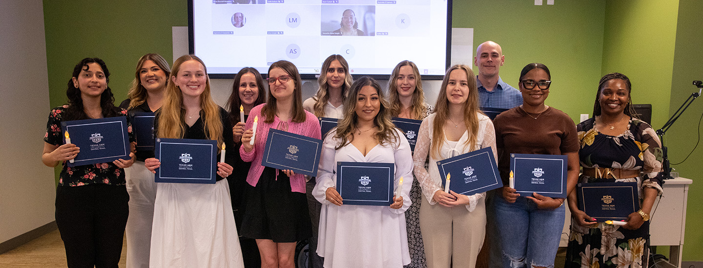 Group of newly inducted Psi Chi Honor Society members pose with their certificates.