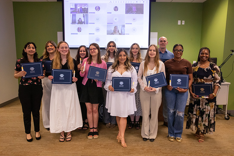 Group of newly inducted Psi Chi Honor Society members pose with their certificates.