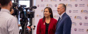 A man and woman stand in front of a step-and-repeat banner with Temple College and A&M–Central Texas logos displayed. They are answering questions from the media.