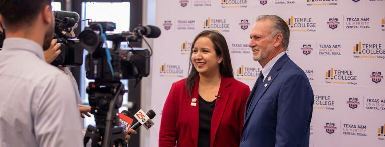A man and woman stand in front of a step-and-repeat banner with Temple College and A&M–Central Texas logos displayed. They are answering questions from the media.