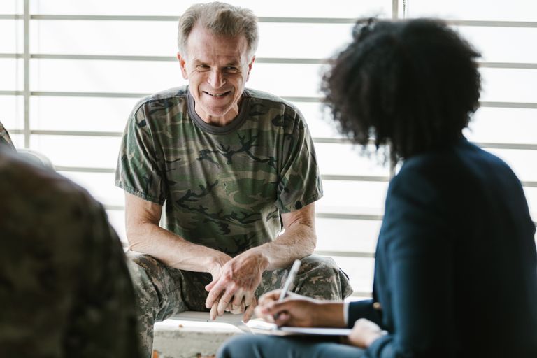 A military veteran engaging in a supportive group therapy session, focusing on mental health.