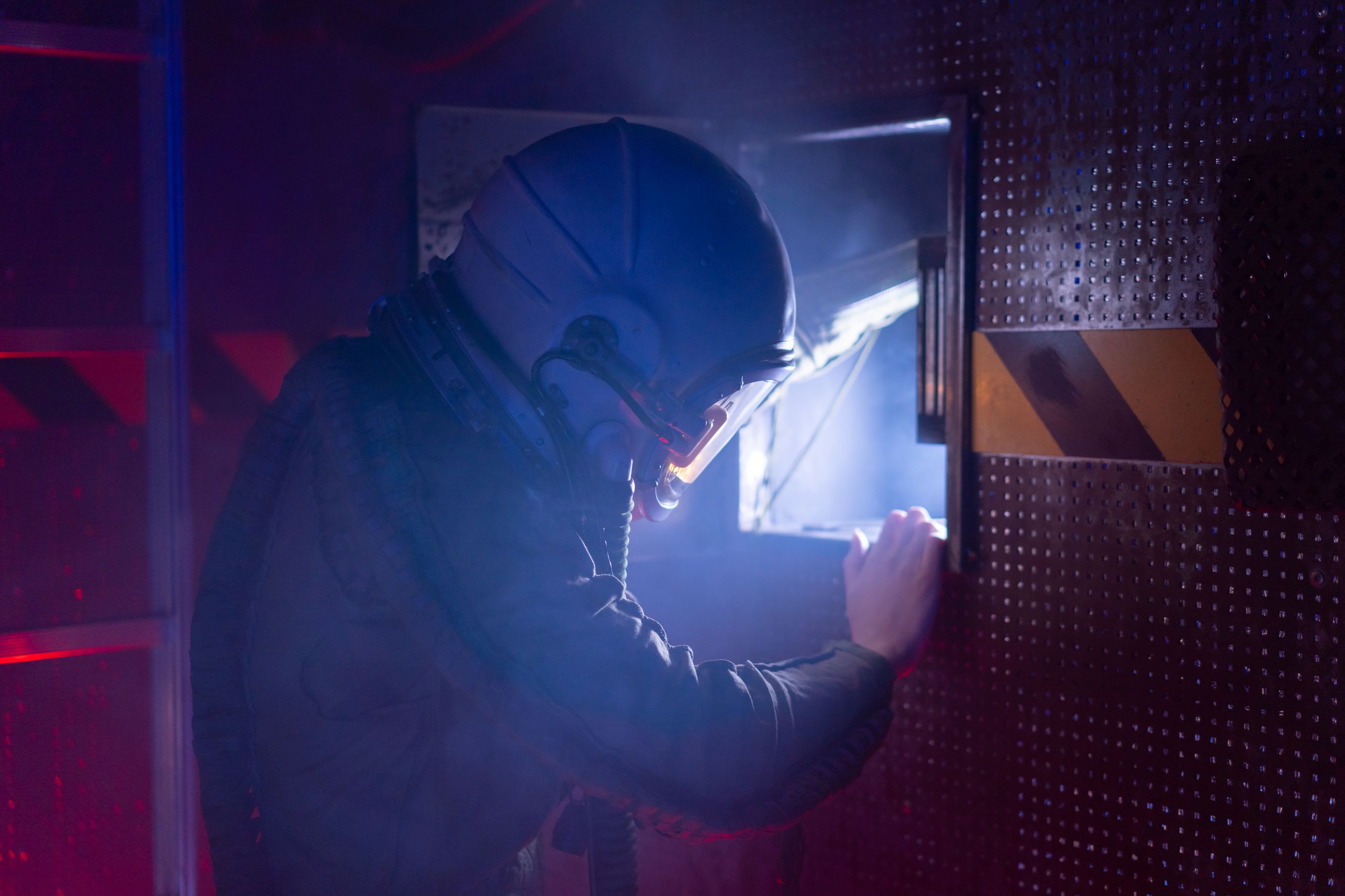 A woman astronaut in a space suit exploring a futuristic spacecraft interior with atmospheric lighting.